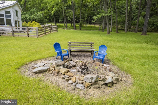 view of yard featuring an outdoor fire pit and fence
