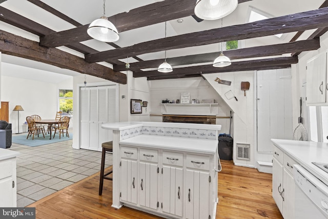 kitchen featuring white cabinetry, light countertops, white dishwasher, and visible vents