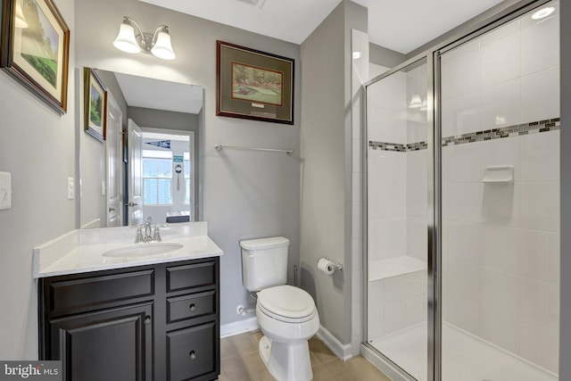 full bathroom with a shower stall, toilet, vanity, baseboards, and tile patterned flooring