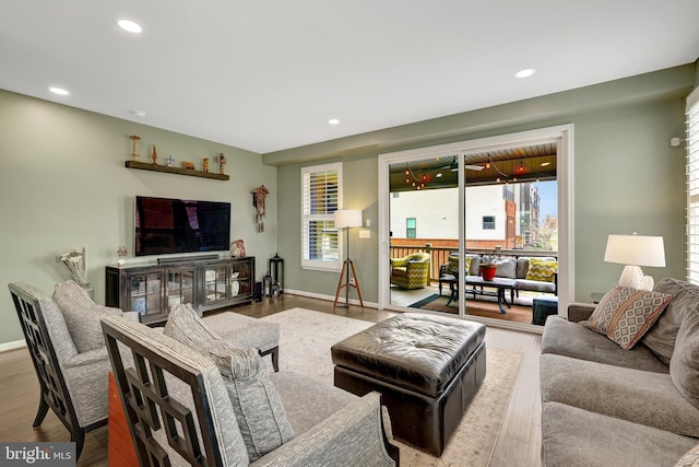 living room with healthy amount of natural light, recessed lighting, wood finished floors, and baseboards