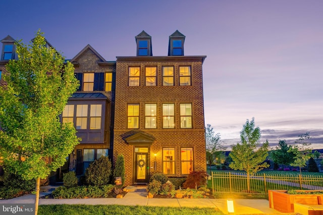 view of front of house with brick siding and fence