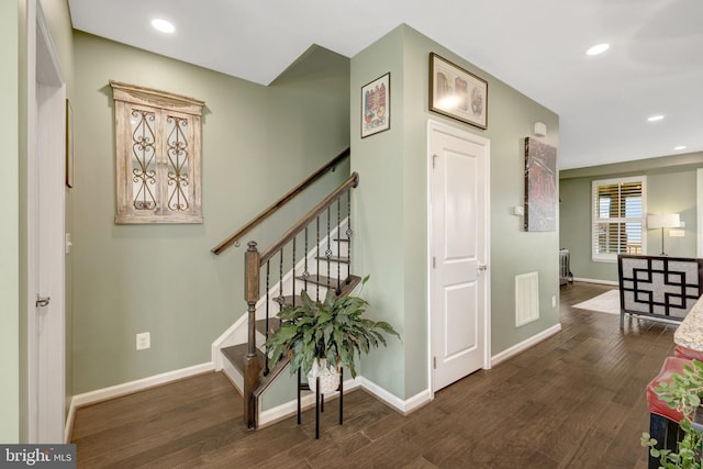 hallway featuring wood finished floors, baseboards, stairs, and recessed lighting