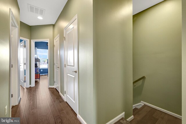 hall featuring wood finished floors, an upstairs landing, and baseboards