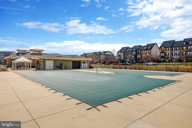 community pool with a residential view, fence, a patio area, and a gazebo