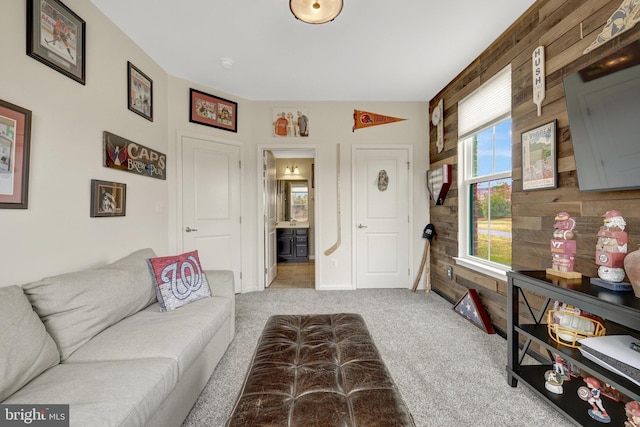 living area featuring light carpet and wooden walls