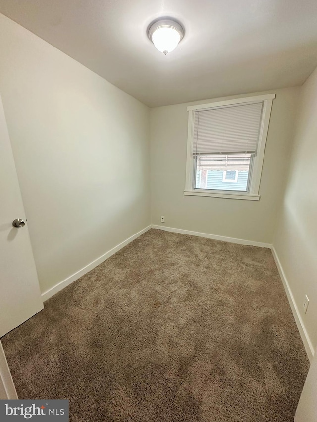 empty room with baseboards and carpet