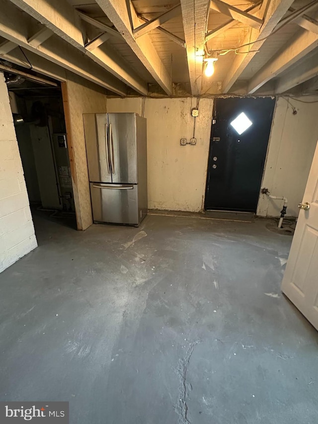 unfinished below grade area featuring freestanding refrigerator
