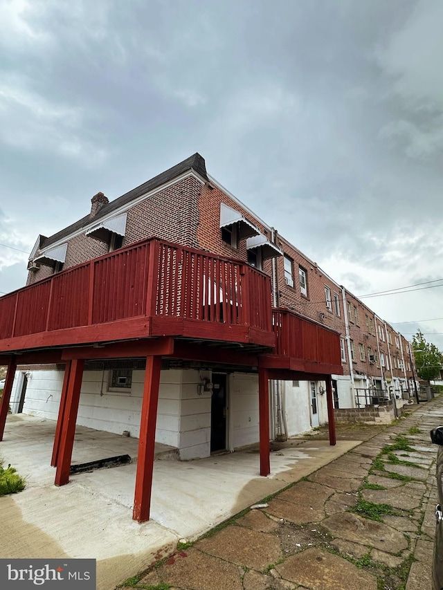 exterior space featuring brick siding and a deck
