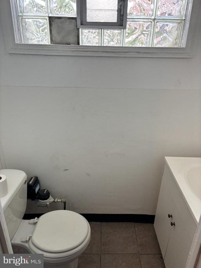 half bathroom featuring vanity, toilet, and tile patterned flooring
