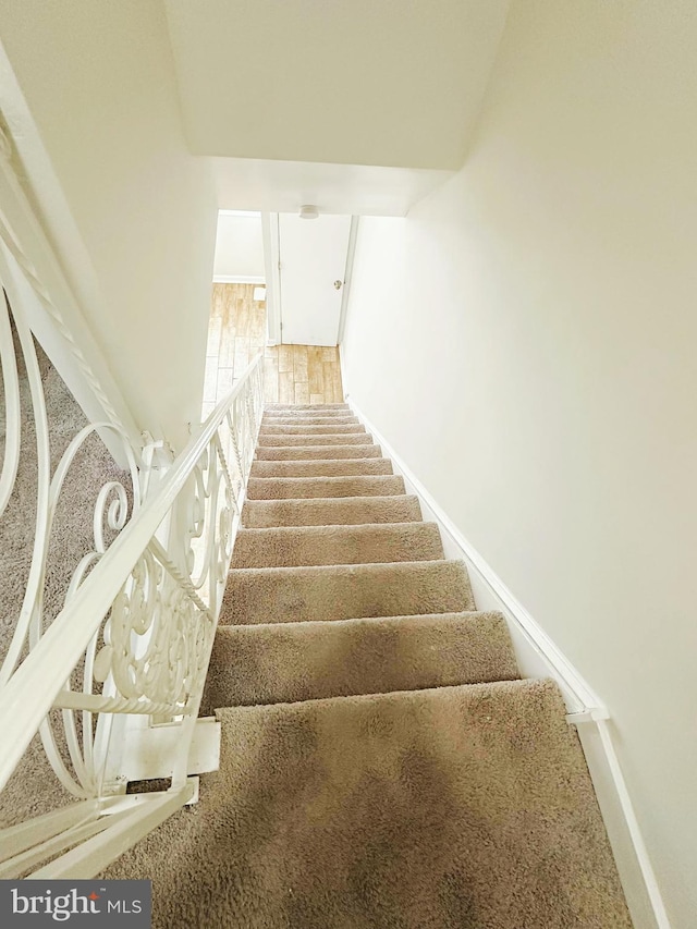 staircase featuring baseboards