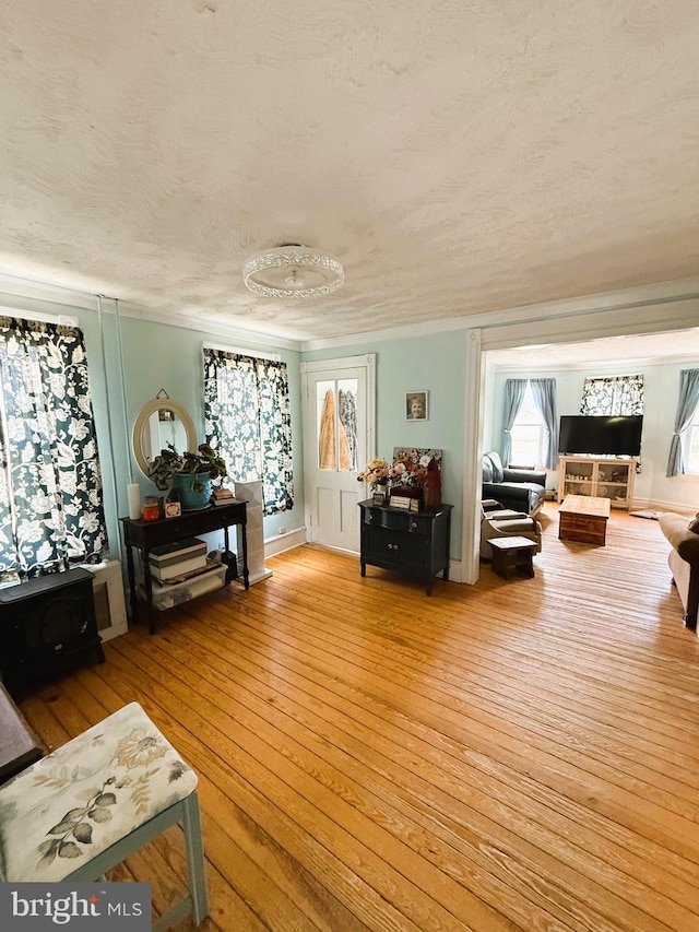 living area with light wood-style flooring and a textured ceiling