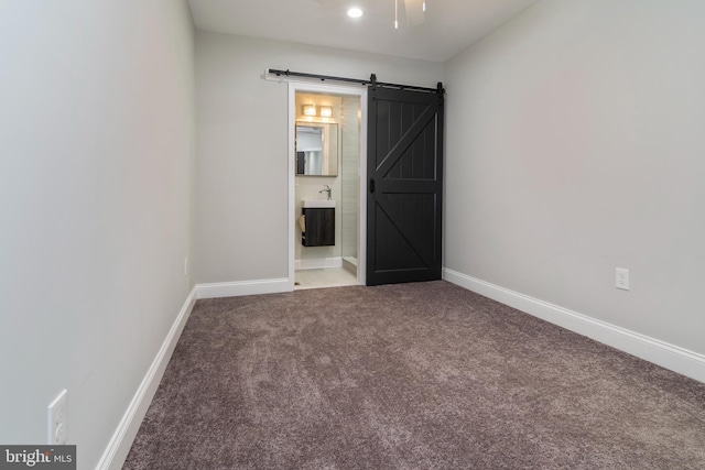 1907 E Lafayette Ave, Baltimore, MD 21213 - unfurnished room featuring a barn door, carpet floors, and baseboards