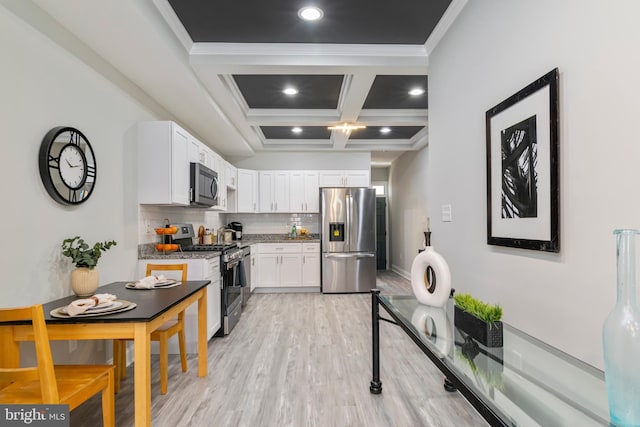 1907 E Lafayette Ave, Baltimore, MD 21213 - kitchen with light wood-style flooring, beam ceiling, white cabinetry, backsplash, and appliances with stainless steel finishes