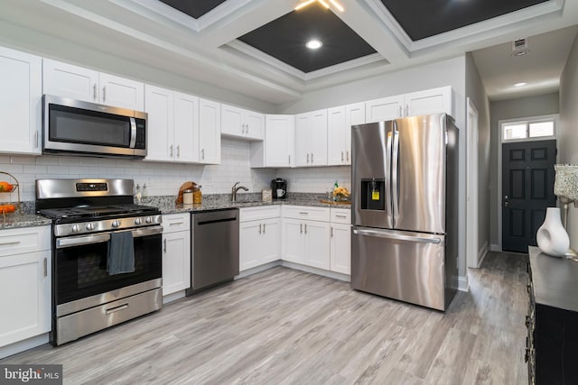 1907 E Lafayette Ave, Baltimore, MD 21213 - kitchen featuring tasteful backsplash, light wood-type flooring, white cabinetry, light stone countertops, and appliances with stainless steel finishes