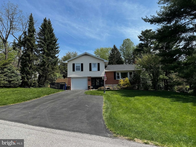 tri-level home with brick siding, asphalt driveway, and an attached garage