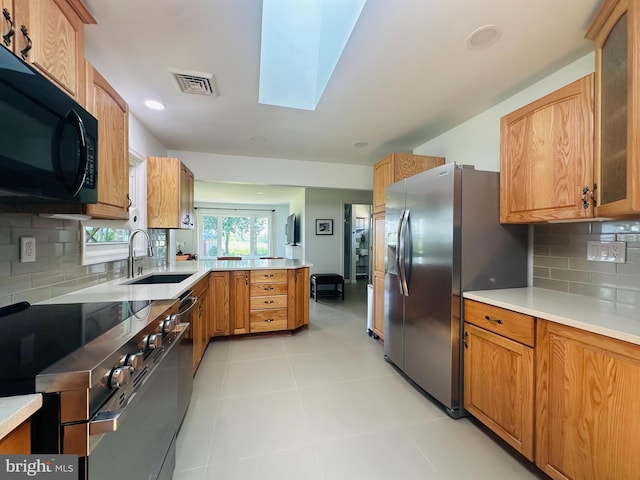 481 Laudermilch Rd, Hershey, PA 17033 - kitchen featuring stainless steel appliances, a sink, a peninsula, a skylight, and decorative backsplash
