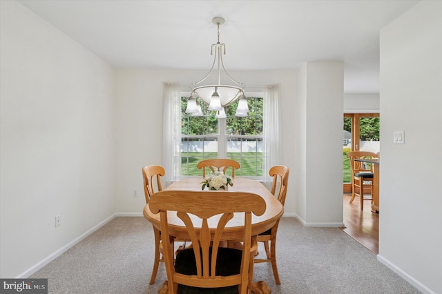 dining area with light colored carpet and baseboards