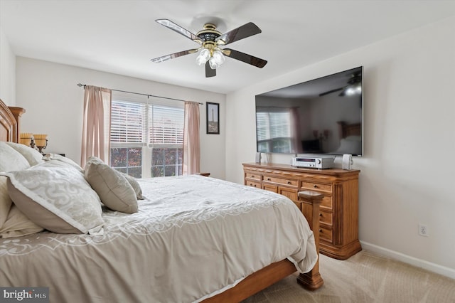 bedroom with light carpet, baseboards, and a ceiling fan
