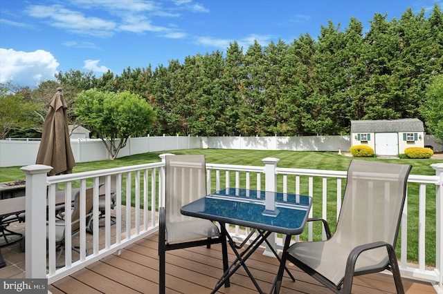 deck featuring a shed, an outdoor structure, and outdoor dining space