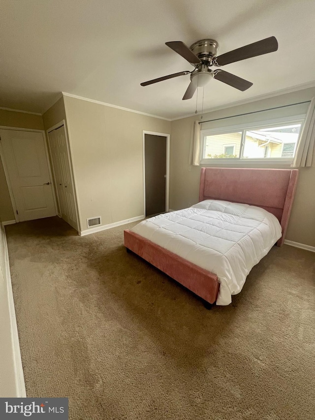 carpeted bedroom with visible vents, baseboards, a ceiling fan, and ornamental molding