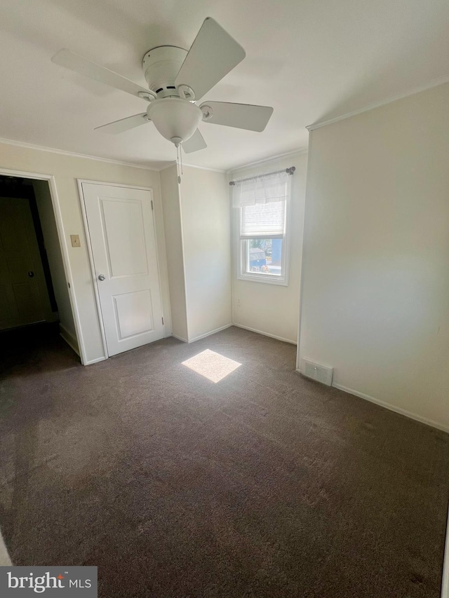 unfurnished bedroom featuring carpet, visible vents, baseboards, and ornamental molding
