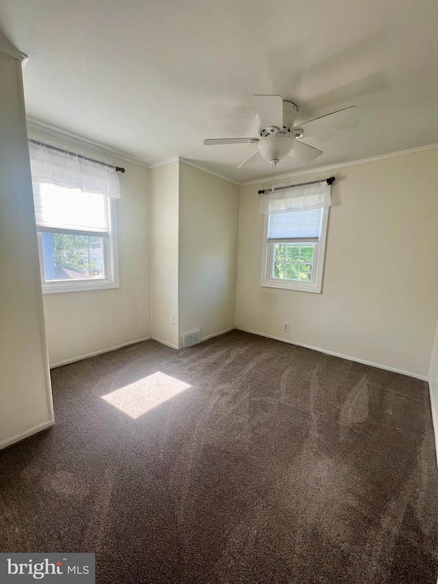 unfurnished room featuring carpet flooring, crown molding, visible vents, and baseboards
