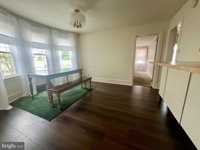 dining space with baseboards, dark wood finished floors, and plenty of natural light