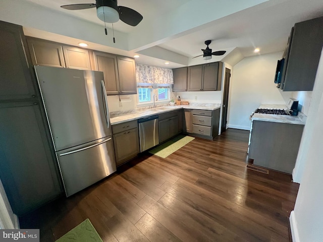 kitchen featuring a ceiling fan, dark wood-style flooring, appliances with stainless steel finishes, and a sink