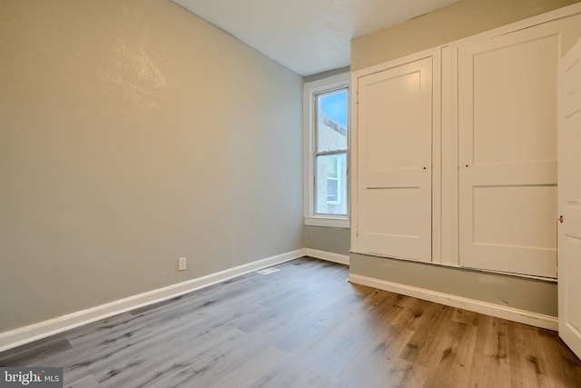unfurnished bedroom featuring wood finished floors and baseboards
