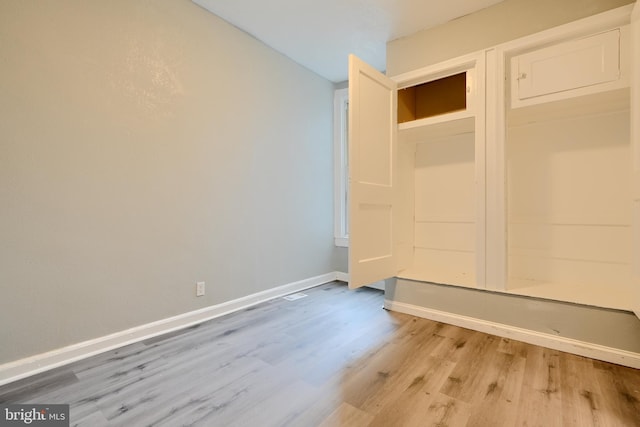 mudroom featuring light wood finished floors and baseboards