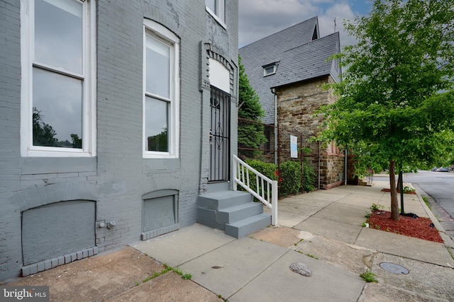 doorway to property with brick siding