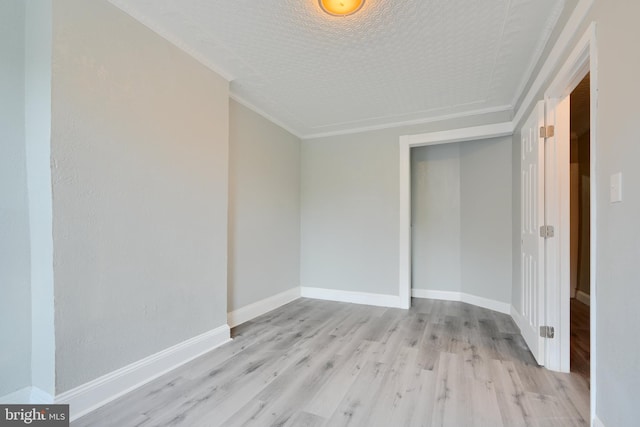 unfurnished room featuring light wood-type flooring, baseboards, and ornamental molding