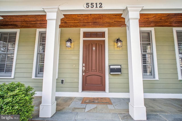 view of exterior entry featuring covered porch