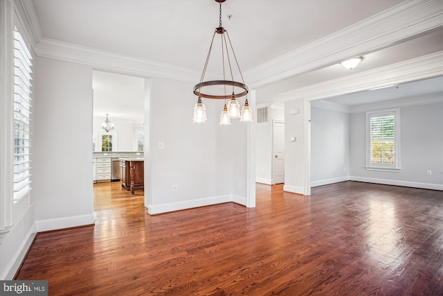 unfurnished dining area featuring wood finished floors, ornamental molding, baseboards, visible vents, and a notable chandelier