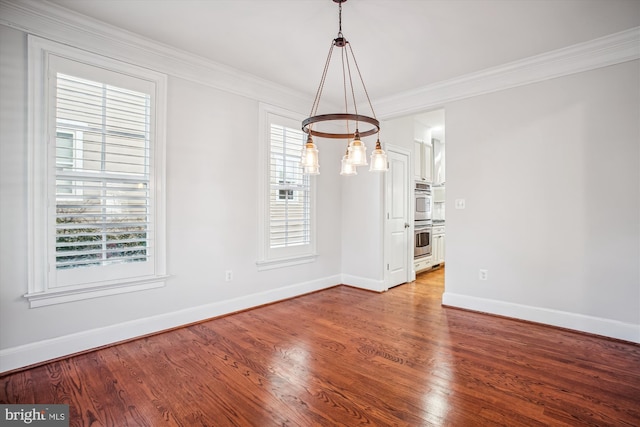 unfurnished dining area featuring wood finished floors, baseboards, and ornamental molding