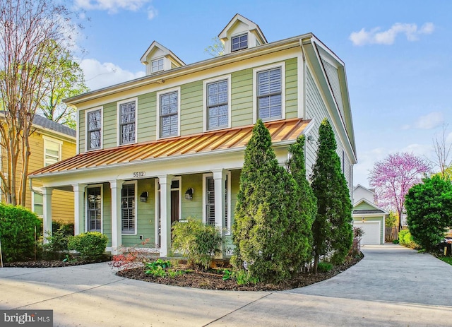 view of front of house featuring a porch, an outdoor structure, metal roof, and a standing seam roof