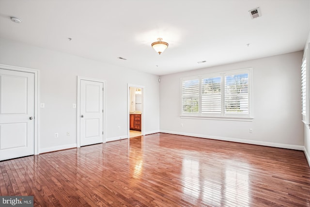interior space featuring baseboards, visible vents, and hardwood / wood-style flooring
