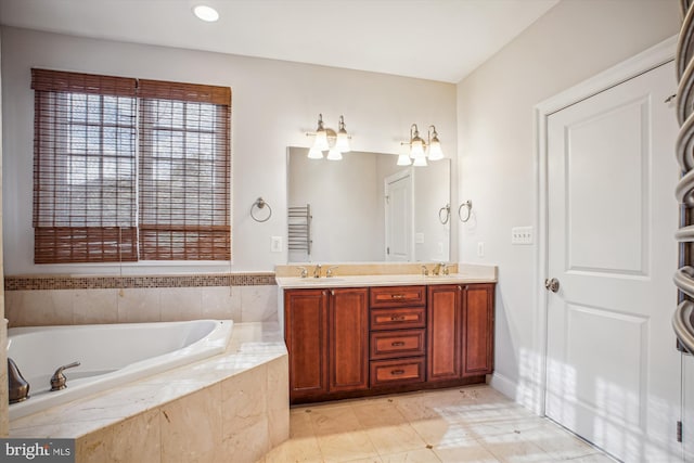 bathroom with double vanity, a garden tub, and a sink