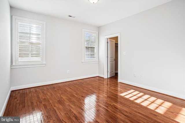 unfurnished bedroom featuring visible vents, wood finished floors, and baseboards