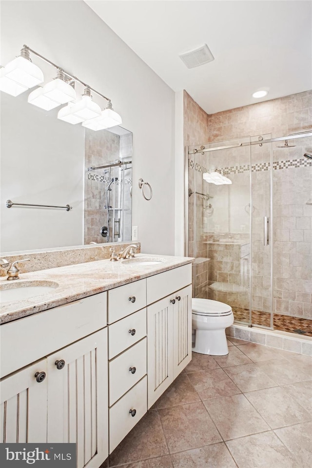 bathroom featuring a sink, double vanity, and a shower stall