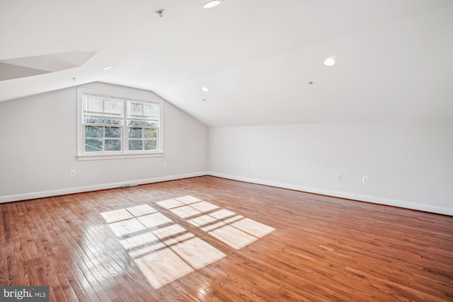 bonus room featuring vaulted ceiling, wood-type flooring, and baseboards
