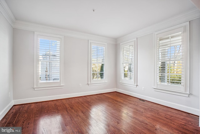 empty room featuring baseboards and crown molding