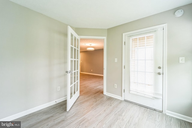 entryway with french doors, light wood-style flooring, and baseboards