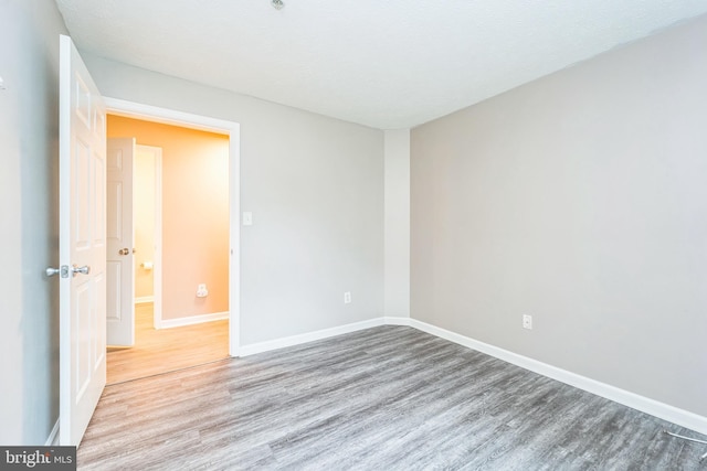 unfurnished room featuring wood finished floors and baseboards