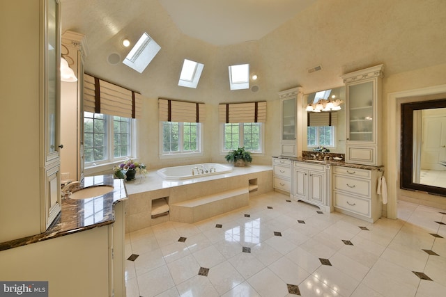 1389 Lamplighter Cir, Gwynedd, PA 19436 - bathroom featuring a skylight, a towering ceiling, tile patterned floors, a bath, and vanity