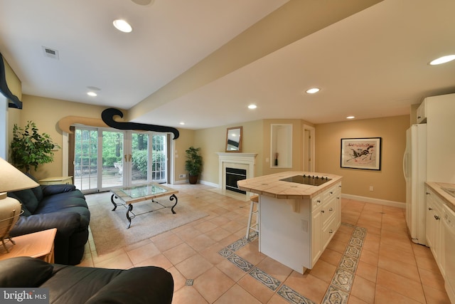 1389 Lamplighter Cir, Gwynedd, PA 19436 - kitchen with open floor plan, tile counters, black electric stovetop, freestanding refrigerator, and light tile patterned floors