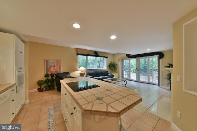 1389 Lamplighter Cir, Gwynedd, PA 19436 - kitchen with tile countertops, white appliances, light tile patterned flooring, open floor plan, and recessed lighting