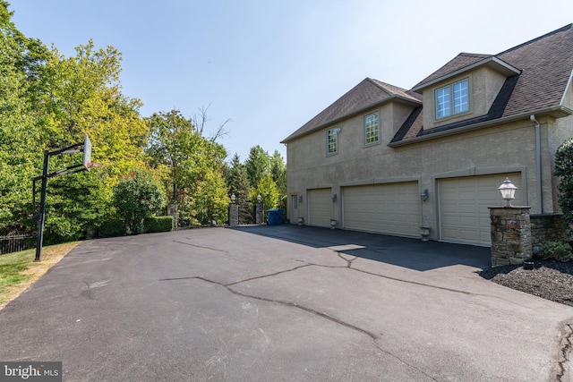 1389 Lamplighter Cir, Gwynedd, PA 19436 - view of home's exterior featuring driveway, an attached garage, roof with shingles, stucco siding, and fence