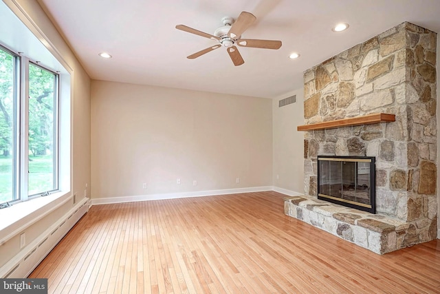 unfurnished living room with a baseboard radiator, light wood-style floors, a ceiling fan, a fireplace, and baseboards
