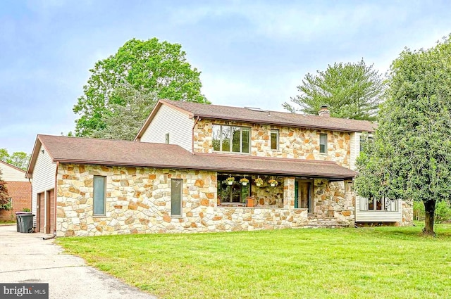 view of front facade featuring stone siding, covered porch, a chimney, and a front lawn